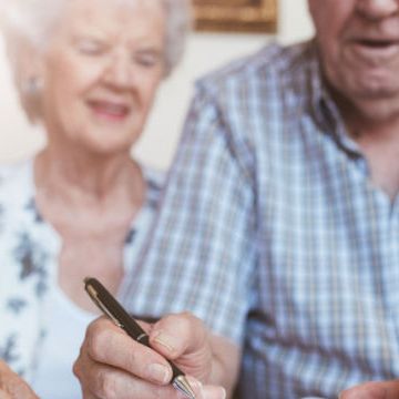 Eldre par signerer papirer